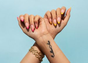Mujer con uñas acrílicas de colores